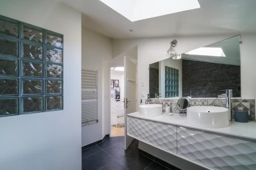Un baño con dos lavabos y un espejo grande. en Atelier loft proche Halles Tours, en Tours
