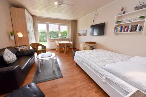 ein Schlafzimmer mit einem Bett, einem Sofa und einem Tisch in der Unterkunft Haus Kehrwieder Appartement KEHR8 in Cuxhaven