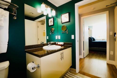 een badkamer met een wastafel en een groene muur bij Adorable 12th Floor Standard Unit Parking Included in Miami