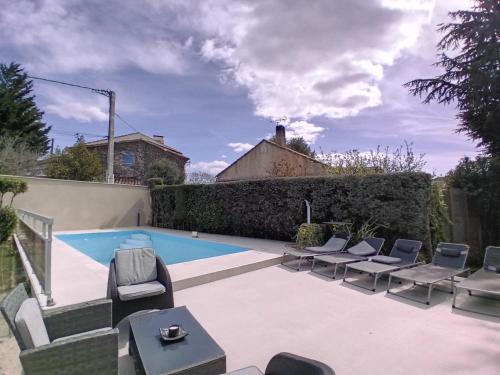 un patio avec des chaises et une piscine dans l'établissement Villa sophora, à Gignac-la-Nerthe