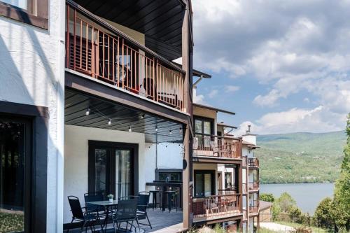 a house with a balcony with a table and chairs at Beautiful Condo 3-Eleven at Tremblant in Mont-Tremblant