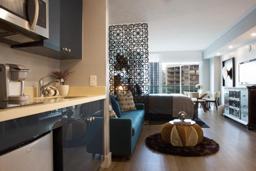 a kitchen and living room with a blue couch and a table at Deluxe Studio in Coconut Grove City and Bay views Includes Parking in Miami