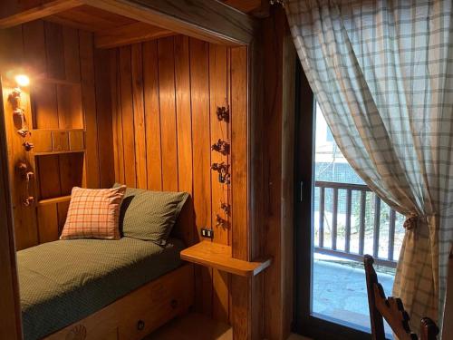 een slaapkamer met een bed in een kamer met een raam bij Relais Courmayeur - Fiore di bosco - Mont Blanc - Italia in Courmayeur