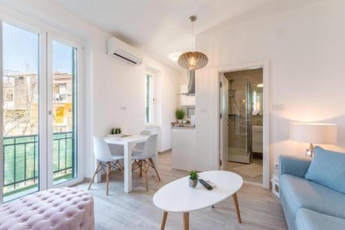 uma sala de estar com um sofá e uma mesa em Apartments and Room Poesia em Split