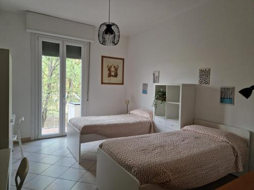 een slaapkamer met 2 bedden en een raam bij HomeLame 57 in Bologna