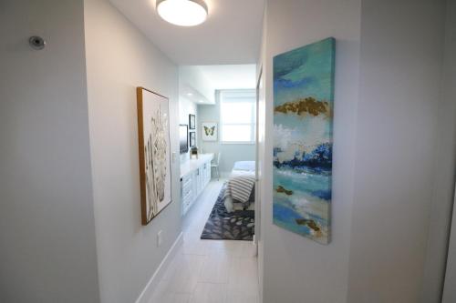 a hallway with three paintings on the walls at Renovated 21st Floor Private Unit located in Coconut Grove Hotel in Miami