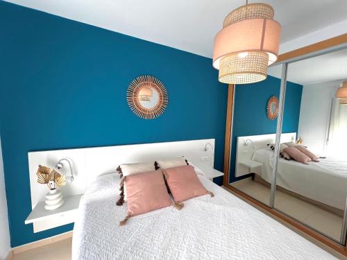 a blue bedroom with a white bed and a mirror at BORA BORA Ático con piscina privada en Vera Paraíso in Vera