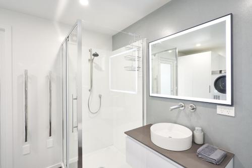 uma casa de banho branca com um lavatório e um chuveiro em Modern Home Near Town em Dunedin
