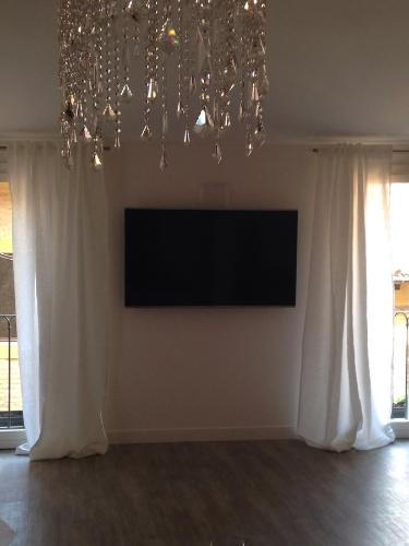 a living room with a television and a chandelier at In Un Borgo Nel Centro Storico in Bologna