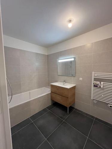 Appartement proche de Genève 2 في Collonges-sous-Salève: حمام مع حوض ومغسلة وحوض استحمام