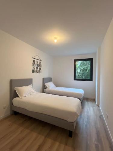 een kamer met 2 bedden en een raam bij Appartement proche de Genève 2 in Collonges-sous-Salève