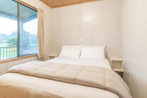 łóżko w pokoju z dużym oknem w obiekcie NRMA Warrnambool Riverside Holiday Park w mieście Warrnambool