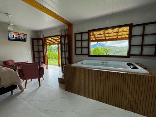 a large bathroom with a large tub with a window at Pousada Vista Pedra Azul in Pedra Azul