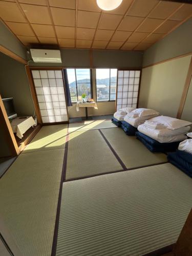 2 camas individuales en una habitación con ventanas en 高島市安曇川町琵琶湖徒歩3分エクシブ 高島 近くBbQ自転車無料貸出, en Takashima