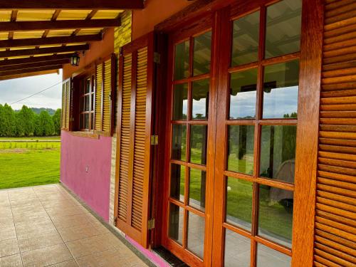 an open door of a building with a view of a field at Pousada Vista Pedra Azul in Pedra Azul
