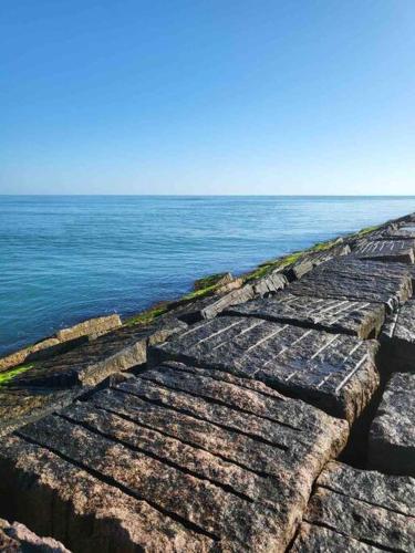 a stone wall next to the water with the ocean at Coronado Get-AWAY at Fantasy Circle in South Padre Island
