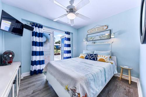 a blue bedroom with a bed and a ceiling fan at Dog-Friendly Beach Apt with Private Yard! in Jacksonville Beach