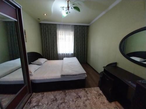 a small bedroom with a mirror and a bed at Apartment for guests in the centre of Tashkent city in Tashkent