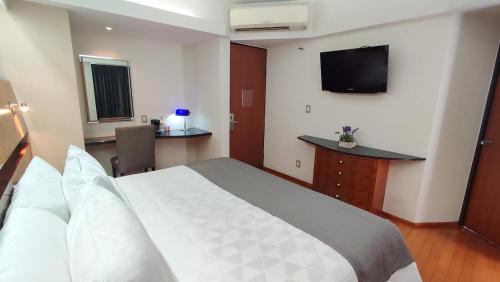 a hotel room with a bed and a flat screen tv at Hotel Roosevelt Condesa in Mexico City