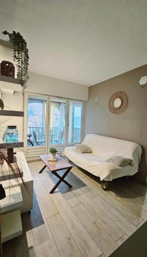 une chambre avec un lit, une table et des fenêtres dans l'établissement Les pieds dans l'eau, à Palavas-les-Flots