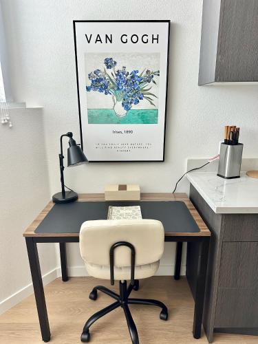 a desk with a chair and a picture on the wall at Nimitz Crossing Luxury Residences in San Diego