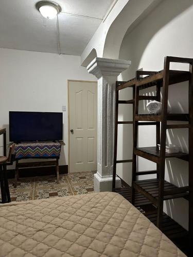 a bedroom with a bunk bed and a room with a tv at NEIZAN HOTEL in Antigua Guatemala