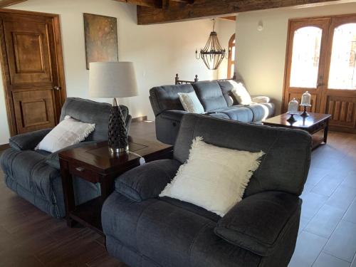 a living room with two couches and a table at Cozy House en Mineral de Pozos in Mineral de Pozos