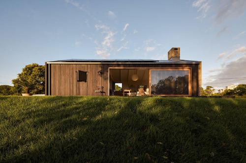 a house with a large window on a grass field at Casa Avalon in Myocum