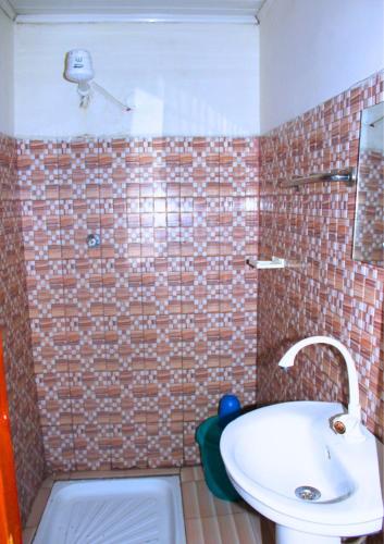 a bathroom with a white sink and a brick wall at KPR 2 in Addis Ababa