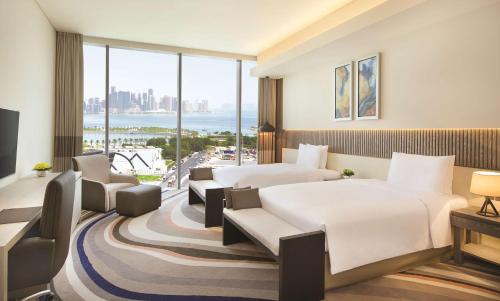 una camera d'albergo con due letti e una grande finestra di DoubleTree by Hilton Doha Old Town a Doha