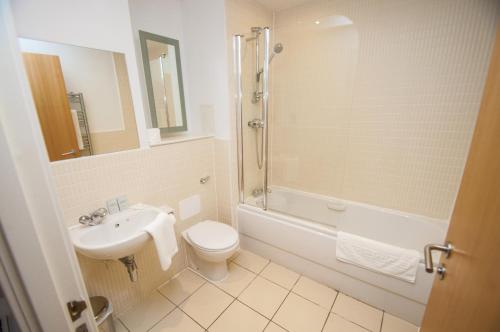 a bathroom with a sink and a toilet and a shower at Ocean Serviced Apartments in Edinburgh