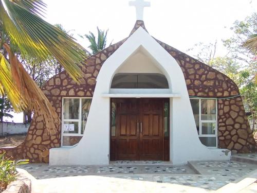 eine kleine Kirche mit einem Kreuz darüber in der Unterkunft HOTEL SANTA VERONICA INN in Santa Veronica