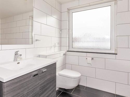 Nørre VorupørにあるHoliday Home Lervejの白いバスルーム(トイレ、窓付)
