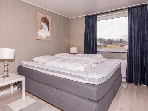 Nørre VorupørにあるHoliday Home Lervejの窓付きのベッドルームの大型ベッド1台