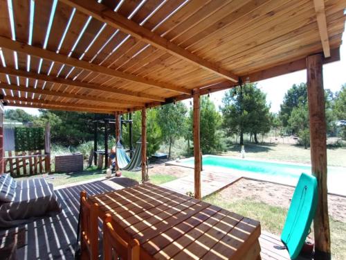 een patio met een houten pergola en een zwembad bij Benirras Beach House in Balneario Sauce Grande