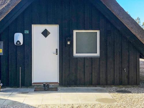 ブラーバンドにある6 person holiday home in Bl vandの白い扉と窓のある納屋