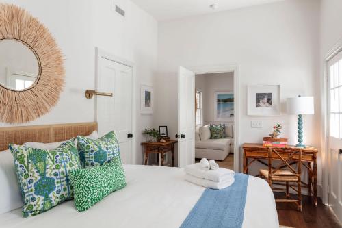 a bedroom with a bed with pillows and a mirror at Blue Cottage at Casa Zoe in Charleston