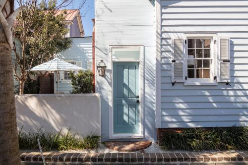 a white house with a blue door at Blue Cottage at Casa Zoe in Charleston