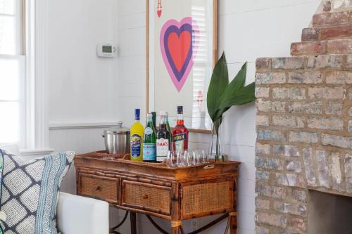 a table with bottles and glasses on it next to a fireplace at Blue Cottage at Casa Zoe in Charleston