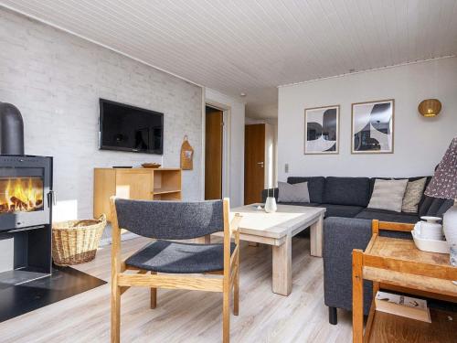 a living room with a couch and a table and a fireplace at 5 person holiday home in Ansager-By Traum in Ansager