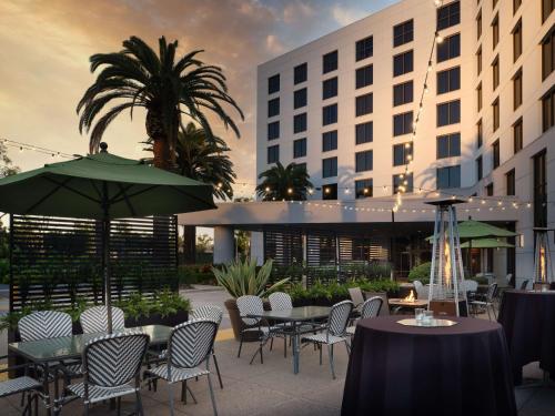 a patio with tables and chairs and a building at DoubleTree by Hilton Irvine Spectrum in Irvine