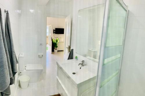 een witte badkamer met een wastafel en een toilet bij La Brisa in Porto do Son