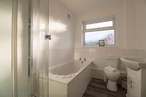 ein Badezimmer mit einer Badewanne, einem WC und einem Waschbecken in der Unterkunft HugeDiscounts Monthly offers in Gateshead