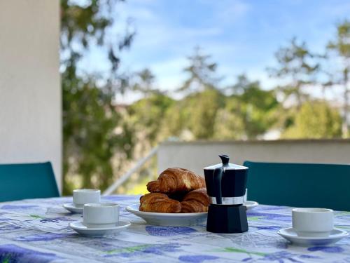 ビビオーネにあるVilla Giorgio 4 Terrazza Privataのクロワッサンとカップ、パンプレート付きのテーブル
