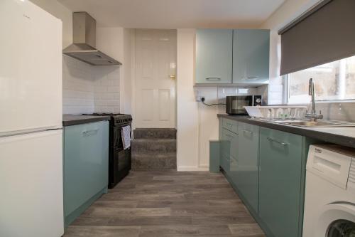 a kitchen with blue cabinets and a sink at HugeDiscounts Monthly offers in Gateshead
