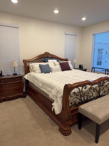 una camera da letto con un grande letto in legno con cuscini di Vacation or Business trip a Downey