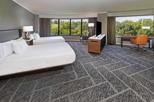 a hotel room with two beds and a desk at DoubleTree by Hilton Tulsa at Warren Place in Tulsa