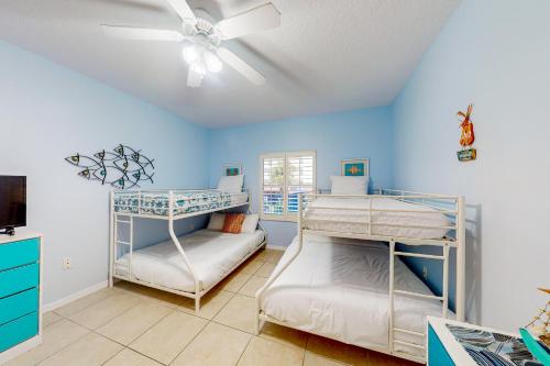 two bunk beds in a room with a ceiling fan at Oceanwalk 10-203 in New Smyrna Beach