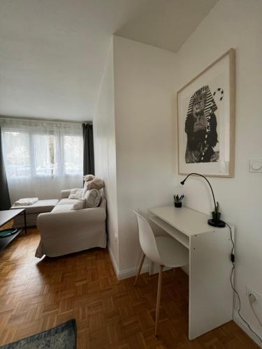 Appartement Cosy et Confortable في سان جيني لافال: غرفة معيشة مع أريكة بيضاء وطاولة