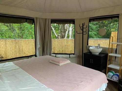 1 dormitorio con cama y lavamanos en Two bedroom tent on the beach private plunge pool, en Matapalo
